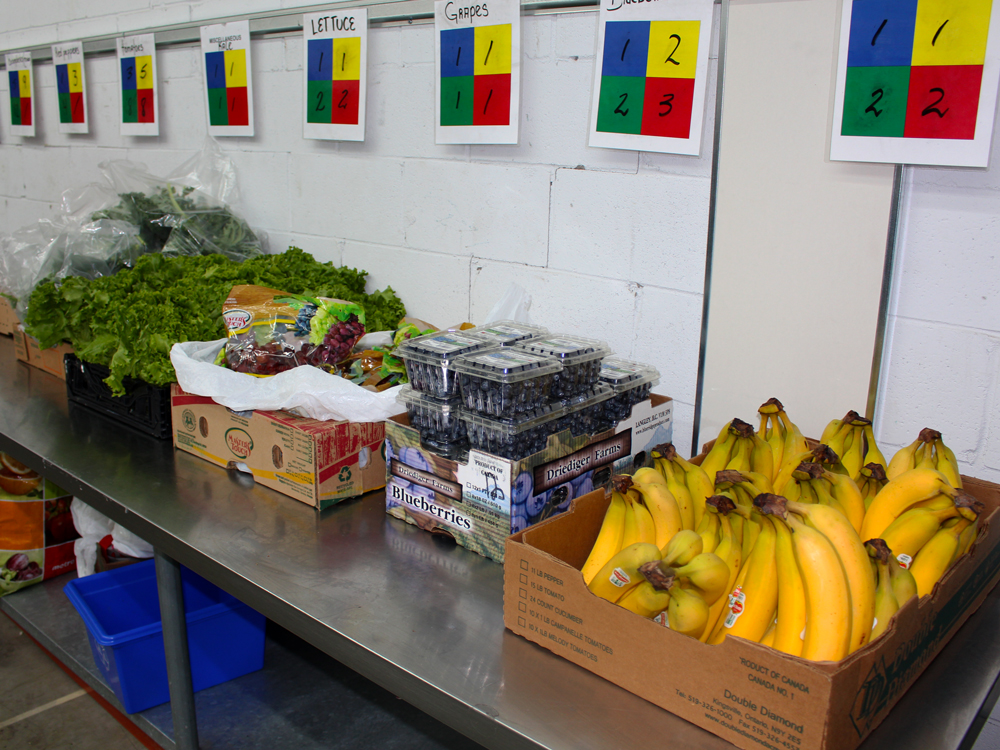 fresh produce laid out for pickup, bananas, blueberries, and kale